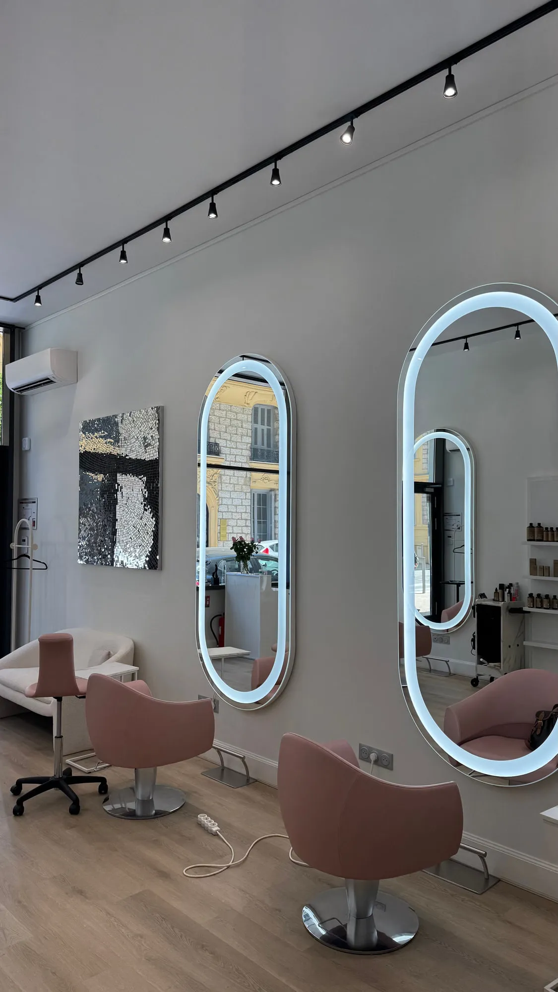 Wow Hair — oval backlit mirrors and dusty-rose chairs along the oak floor