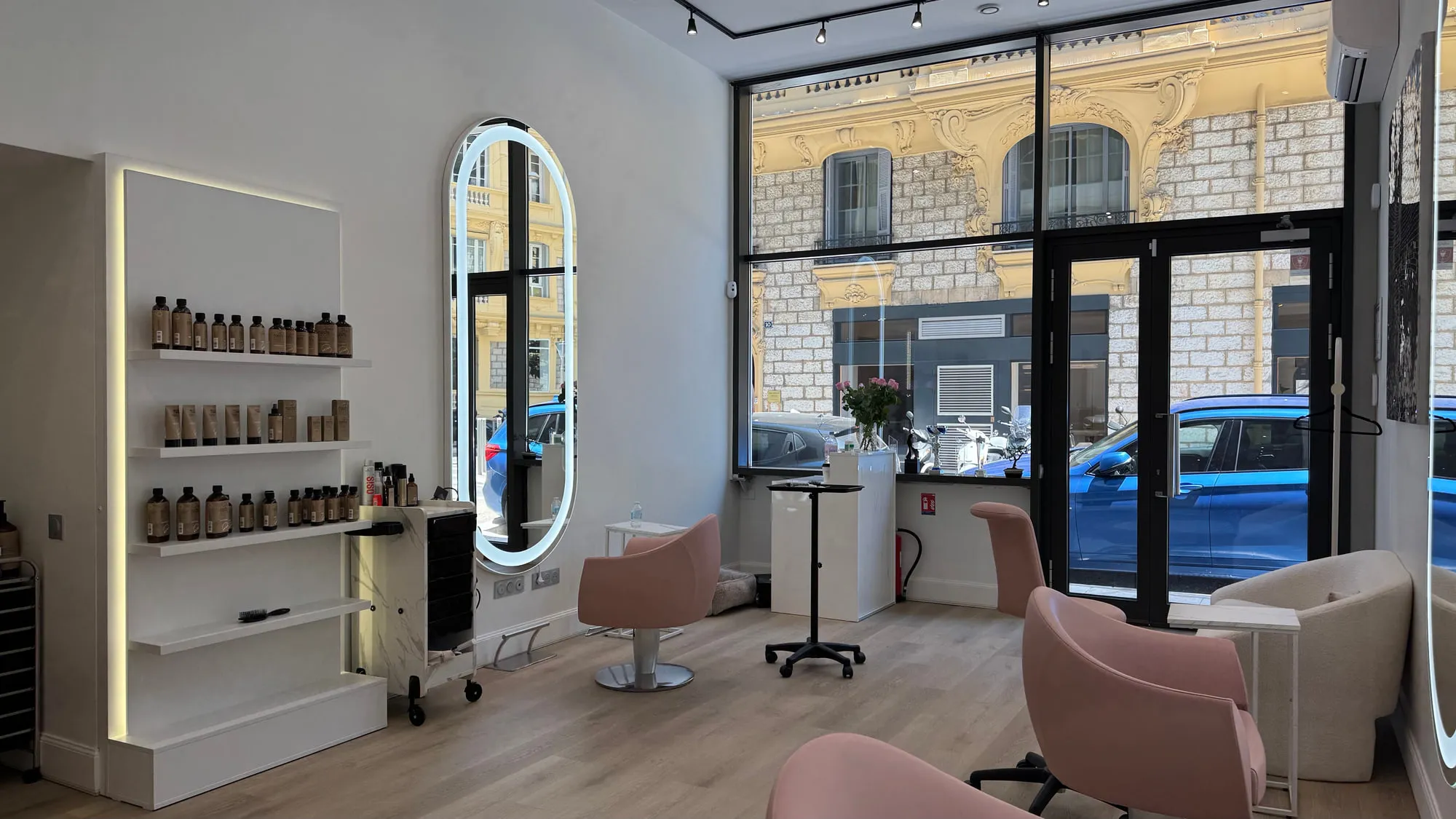 Wow Hair — oval backlit mirrors and dusty-rose chairs along the oak floor