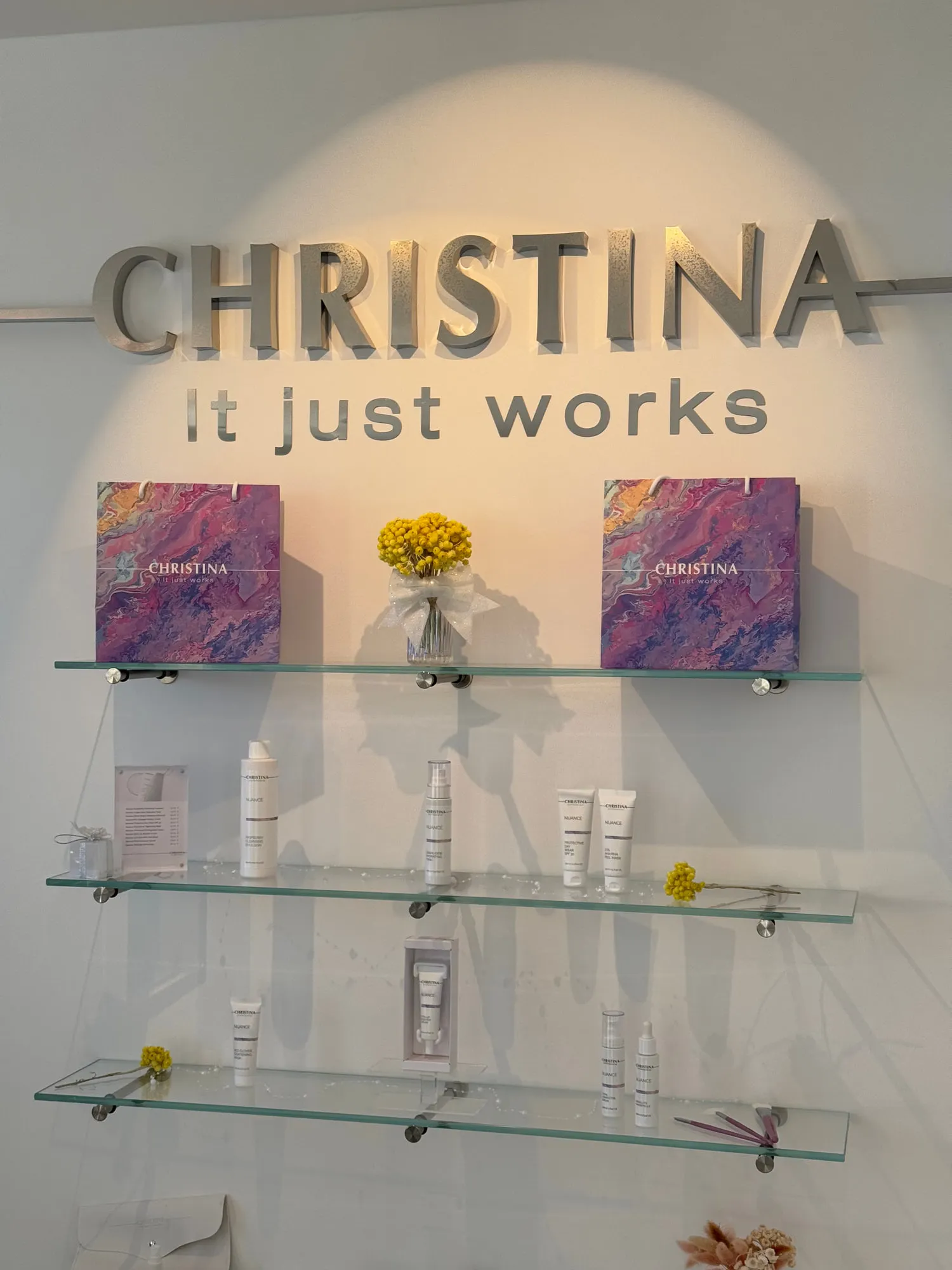 Christina Cannes — arched niches and lit oval mirrors along the salon