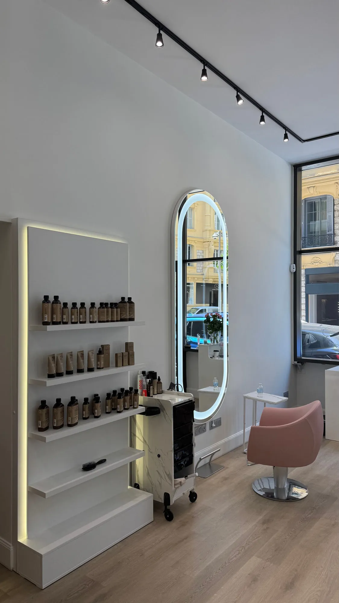 Wow Hair — oval backlit mirrors and dusty-rose chairs along the oak floor