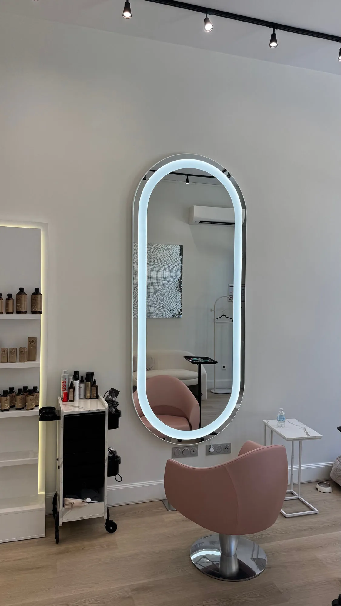 Wow Hair — oval backlit mirrors and dusty-rose chairs along the oak floor