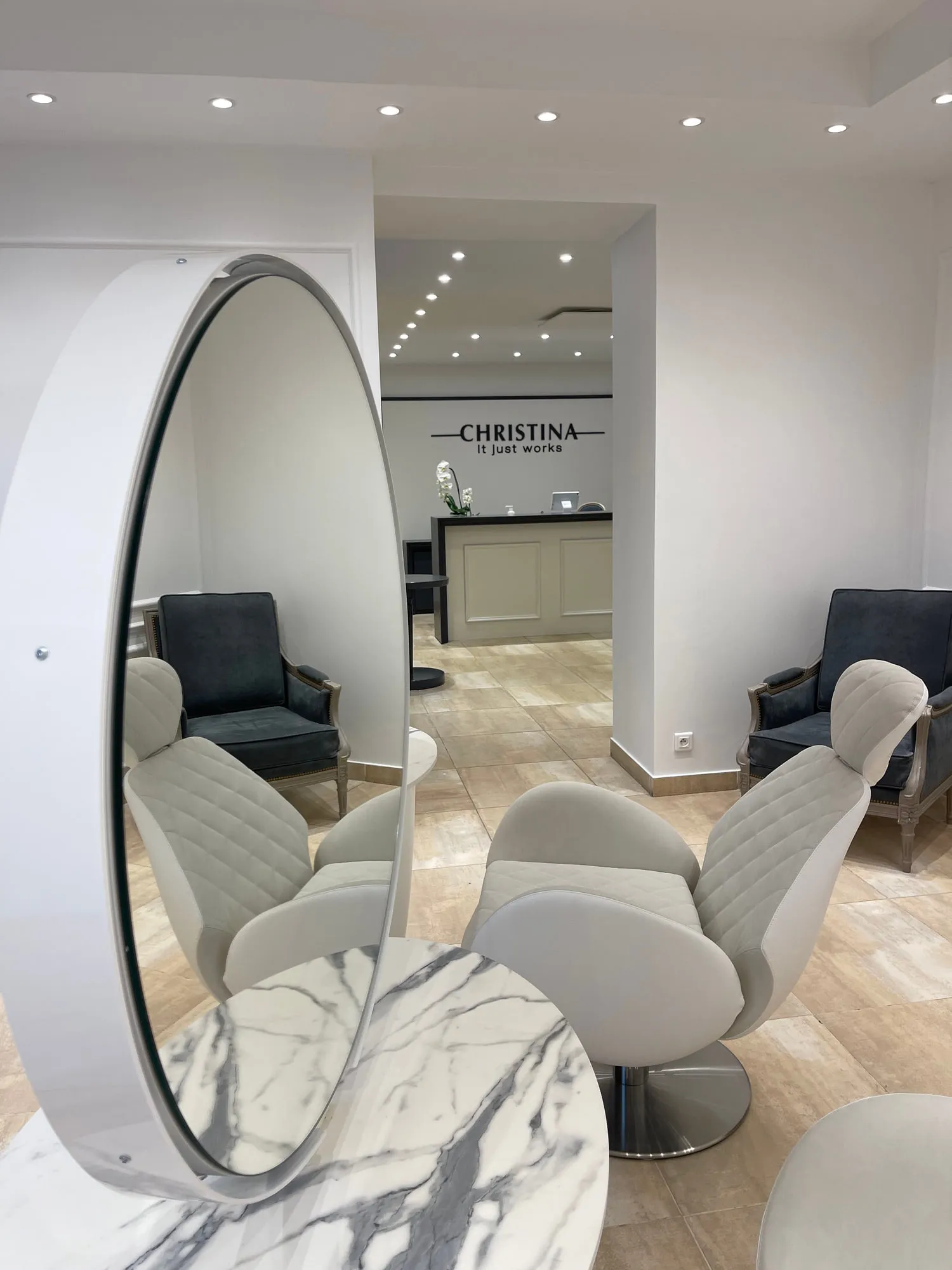 Christina Paris — round mirrors and pedestal stations against exposed Paris limestone