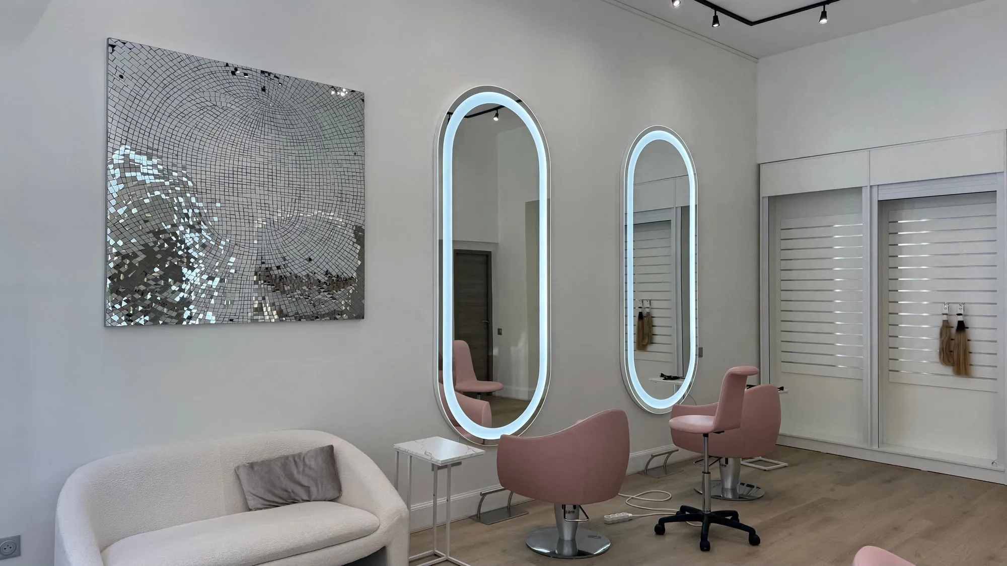 Wow Hair — oval backlit mirrors and dusty-rose chairs along the oak floor