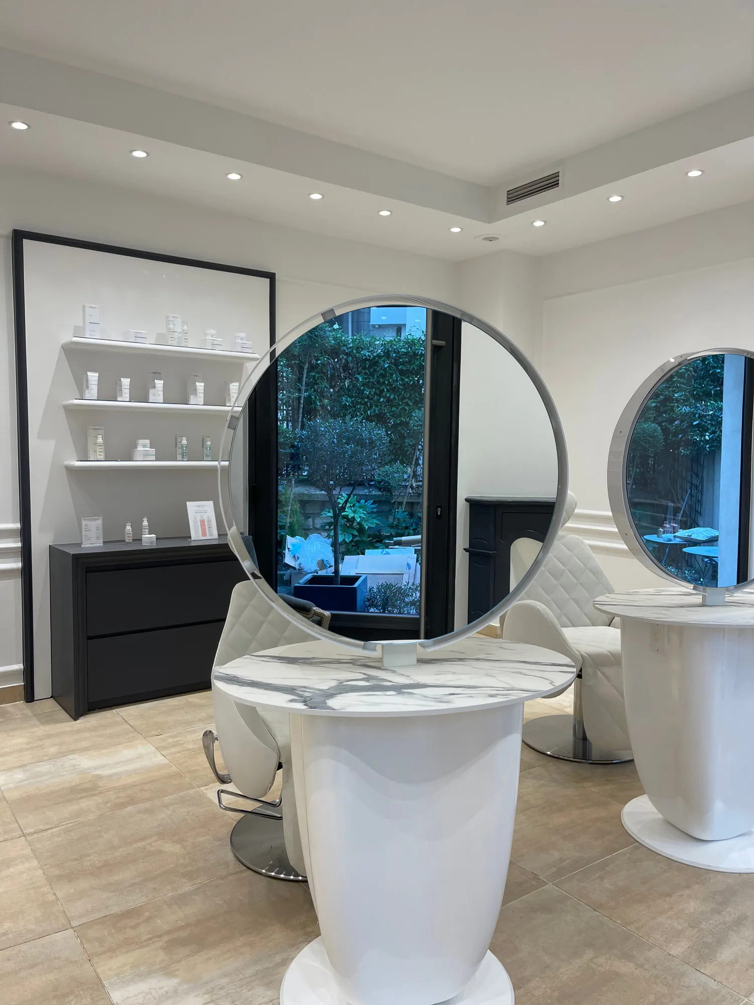 Christina Paris — round mirrors and pedestal stations against exposed Paris limestone