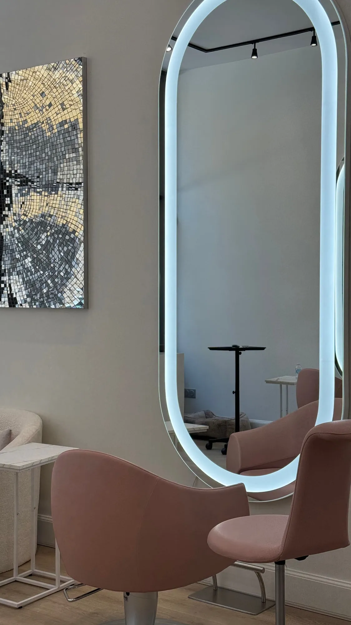 Wow Hair — oval backlit mirrors and dusty-rose chairs along the oak floor