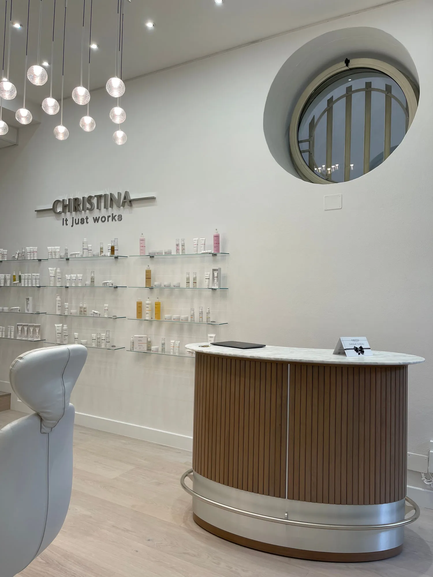 Christina Monaco — arched backlit mirrors above the stations, curved timber reception