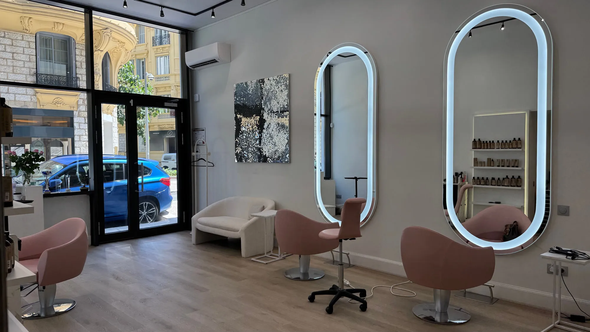Wow Hair — oval backlit mirrors and dusty-rose chairs along the oak floor