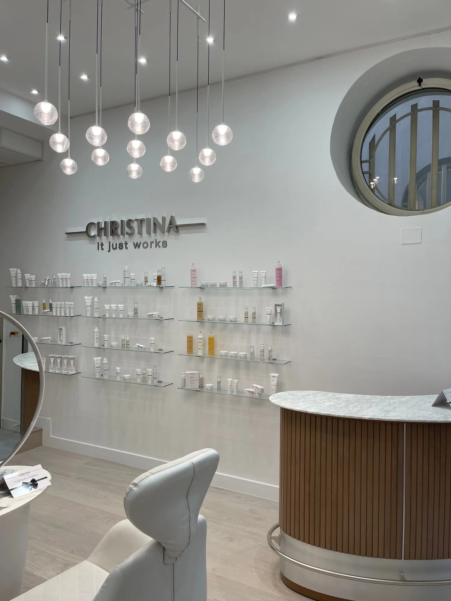 Christina Monaco — arched backlit mirrors above the stations, curved timber reception