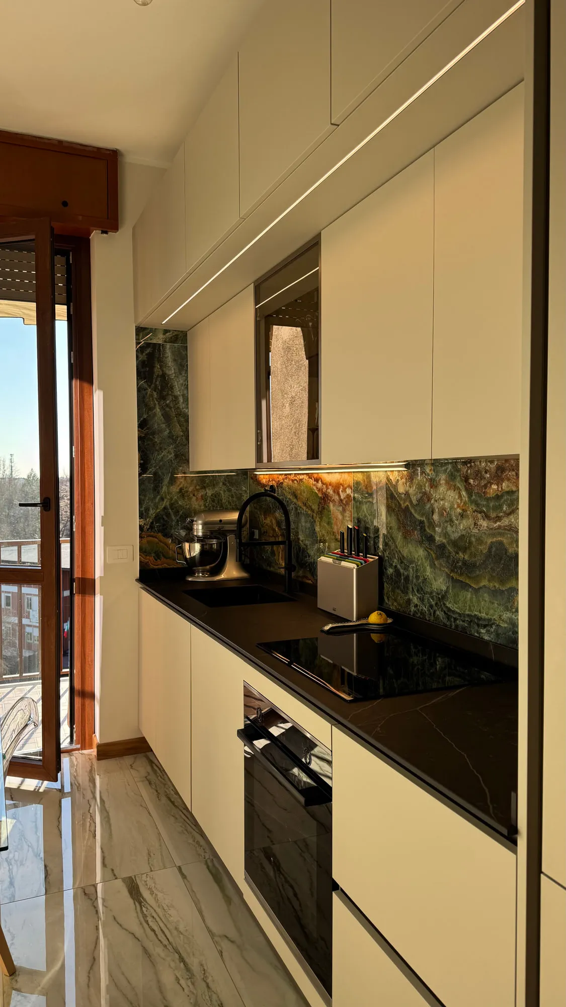 After — The galley kitchen, from patterned tile to a single run of quartzite