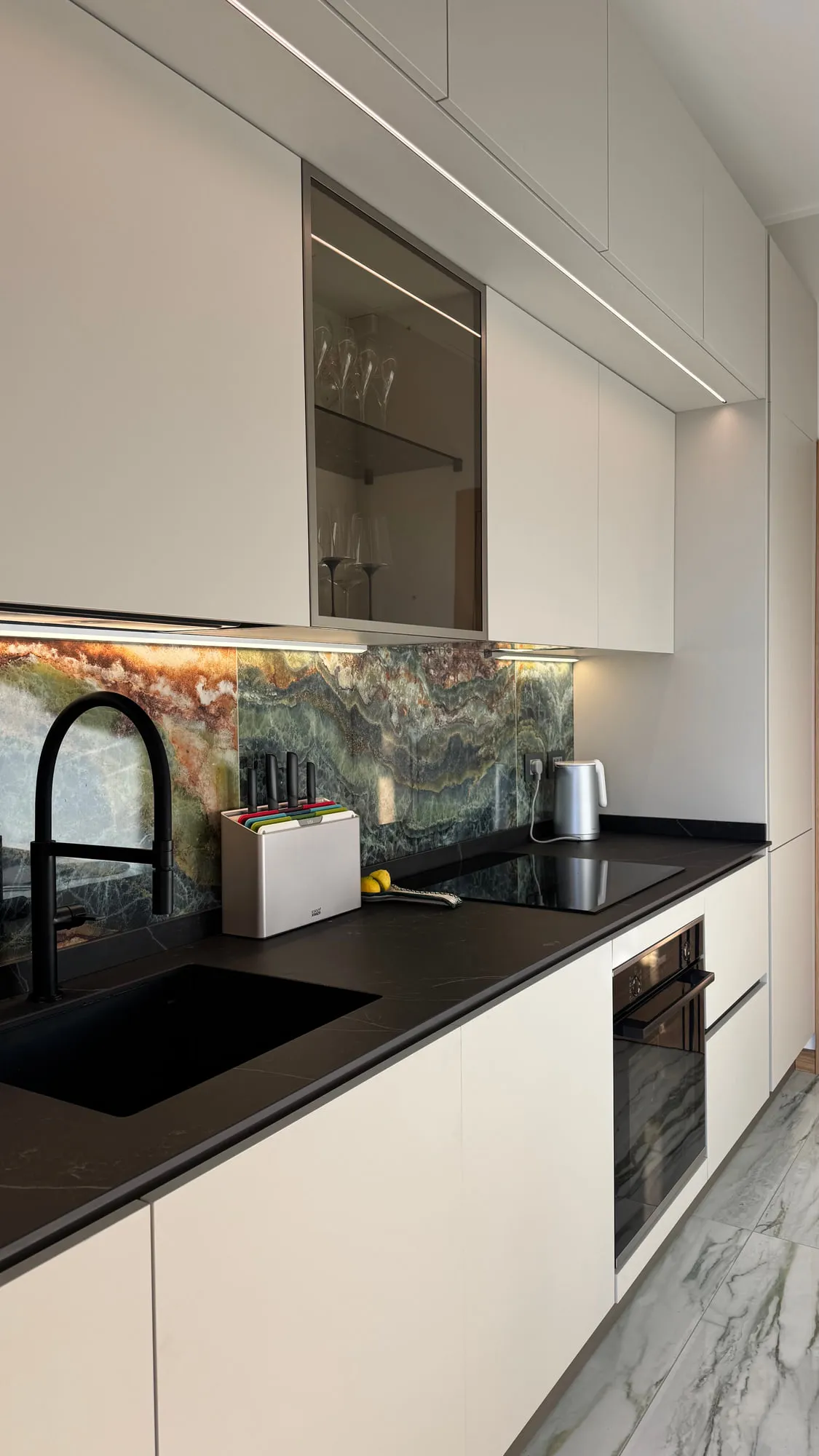 Appartamento Monza — green quartzite against matte lacquer and a black worktop
