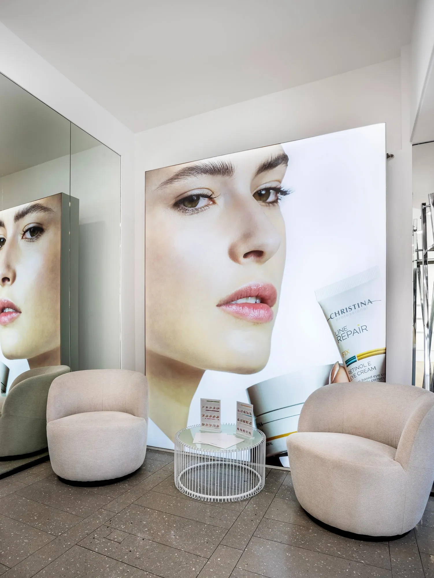 Christina Kassel — the finished salon: oak floor, product wall and backlit round mirrors