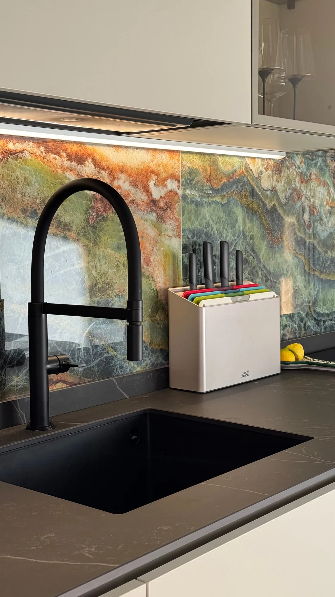 Appartamento Monza — green quartzite against matte lacquer and a black worktop