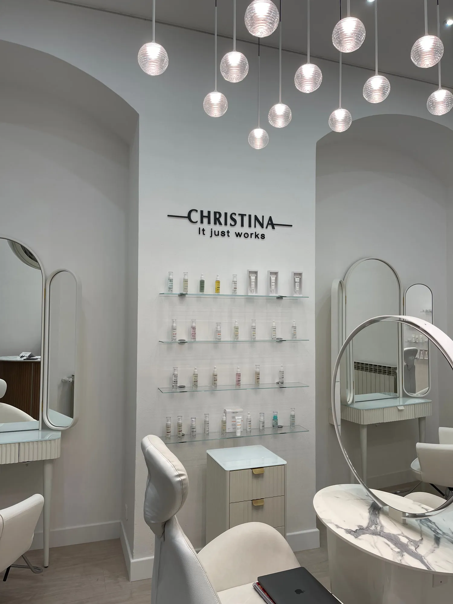 Christina Monaco — arched backlit mirrors above the stations, curved timber reception