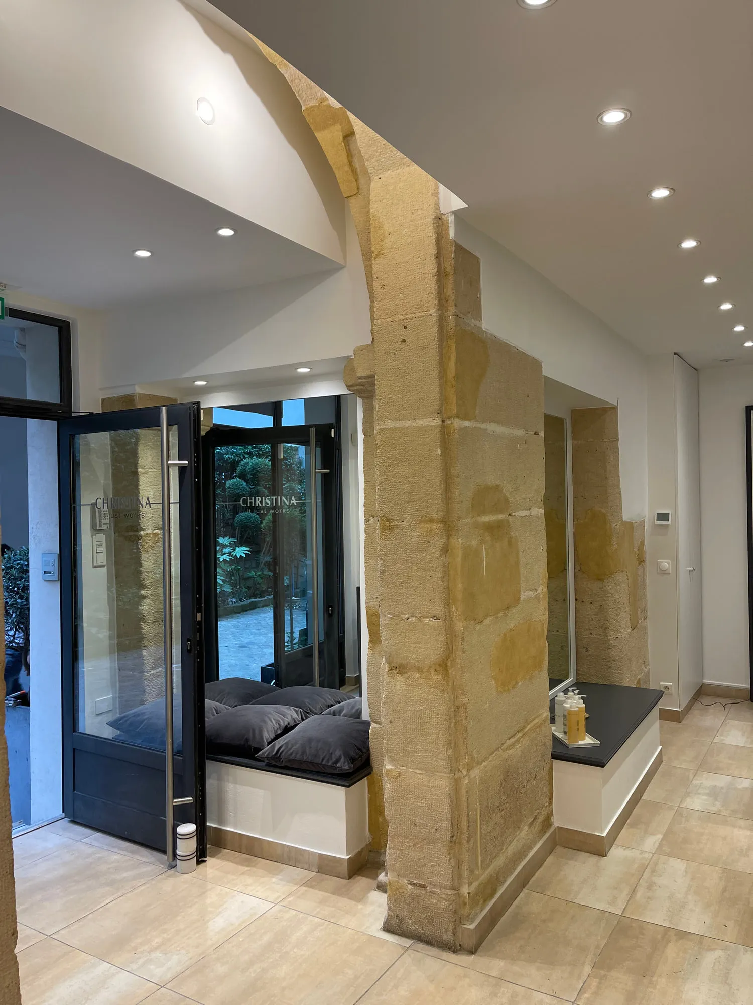 Christina Paris — round mirrors and pedestal stations against exposed Paris limestone