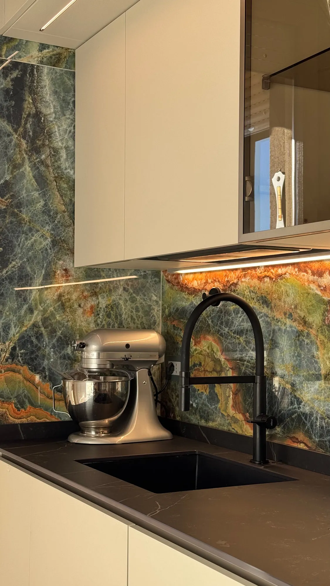 Appartamento Monza — green quartzite against matte lacquer and a black worktop