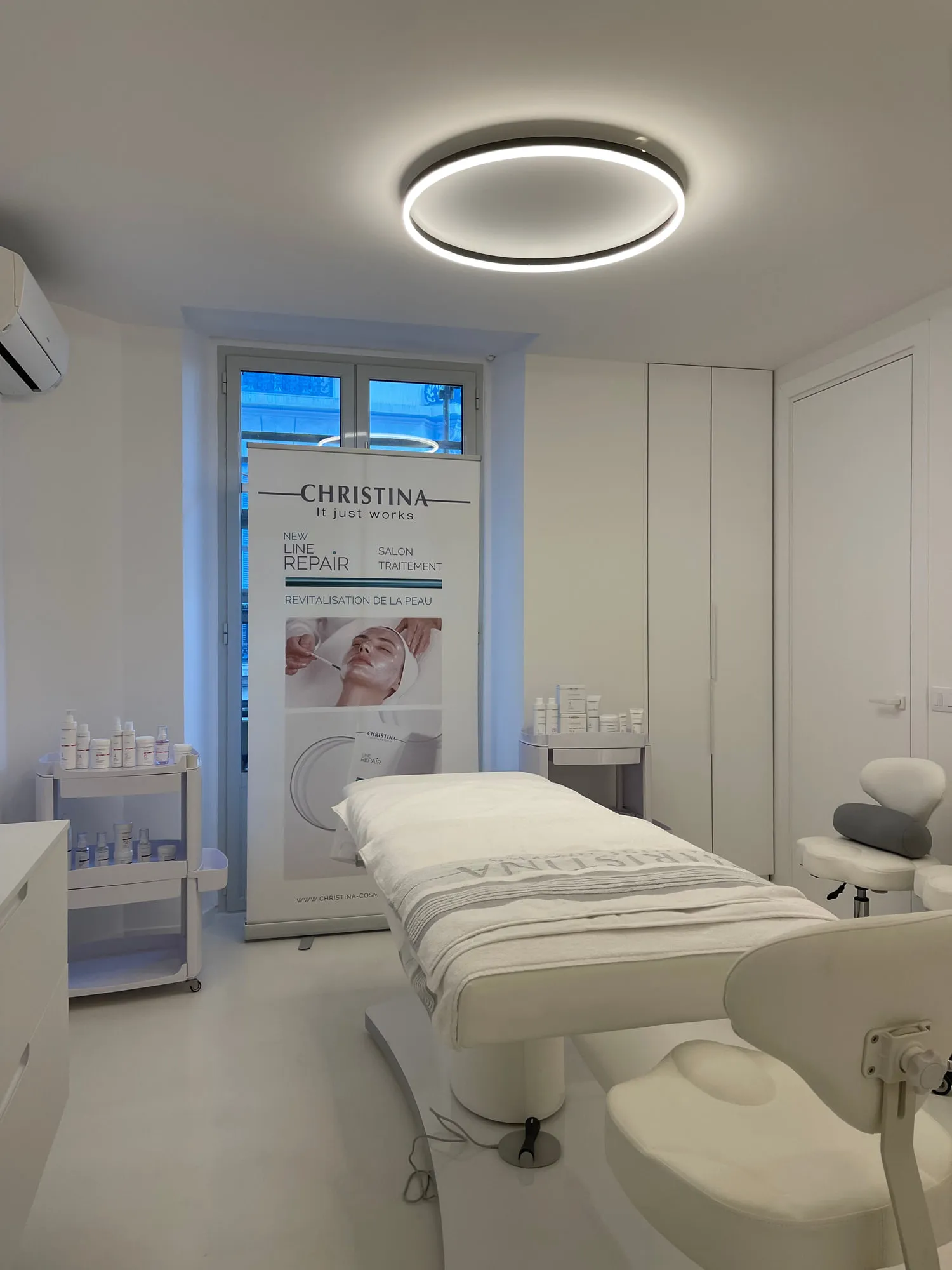 Christina Cannes — arched niches and lit oval mirrors along the salon
