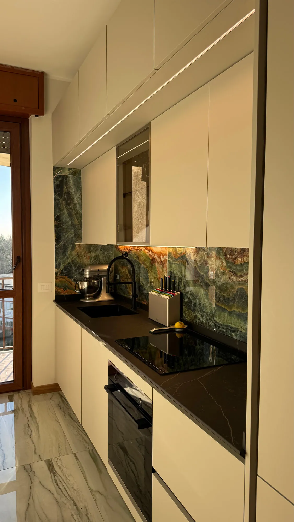 Appartamento Monza — green quartzite against matte lacquer and a black worktop