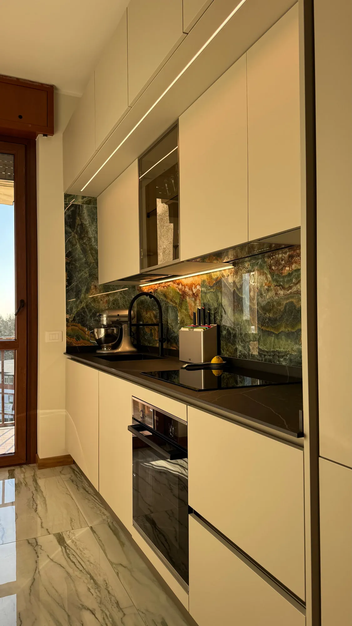 Appartamento Monza — green quartzite against matte lacquer and a black worktop